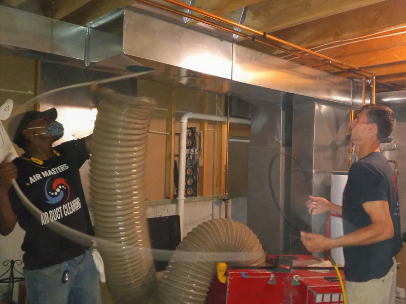 Airmasters employees cleaning air duct