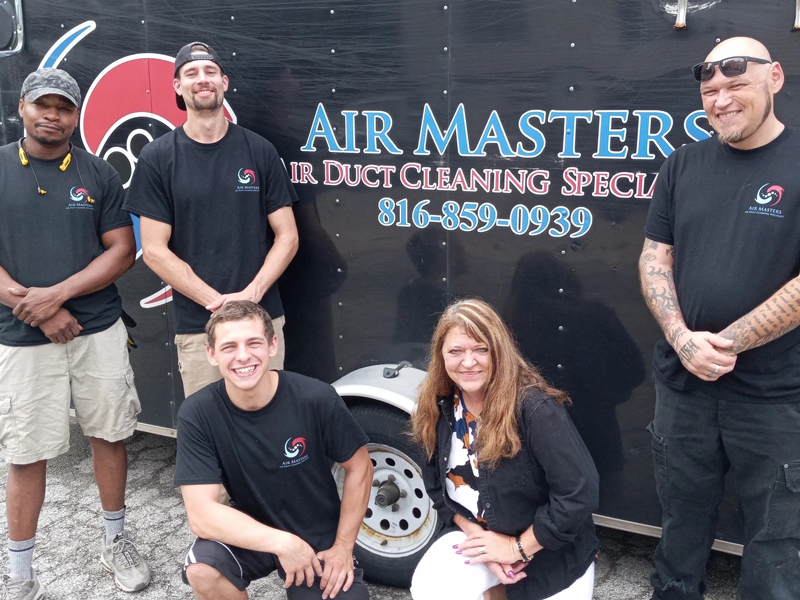 Airmasters Air Duct Cleaning employees in front of company trailer with logo